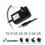 adaptateur secteur convertisseur universel tension100240V sortie5V intensitésvariables polaritéintérieurepositive boîtierplastique noir câble1m connecteurcoaxial55mm21mm prisesinterchangeables européenne américaine britannique australienne compatiblecaméras routeurs boitiermultimedia